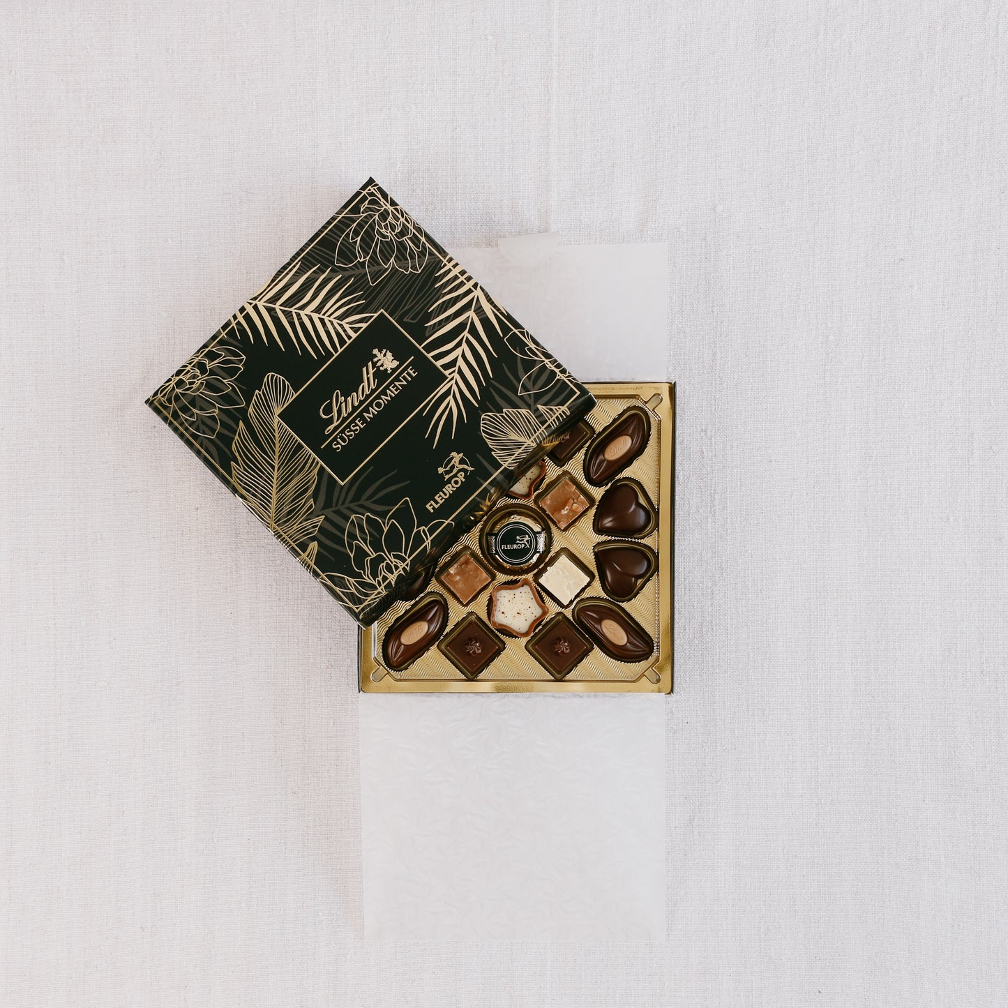 Draufsicht - Lind-Pralinenschachte, schwarz-gold, zur Hälfte geöffnet