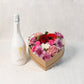 Naturfarbenen Herzkarton mit Saisonblumen und einer Flasche Schlumberger-Sekt