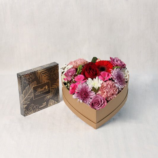 Naturfarbenen Herzkarton mit Saisonblumen und einer Schachtel Lind Pralinen